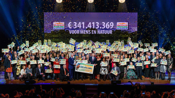 Lucky winners pose on stage with special guest and former US president Bill Clinton at the Annual Charity Gala of the Dutch Postcode Lottery, held on February 6 in Amsterdam. 