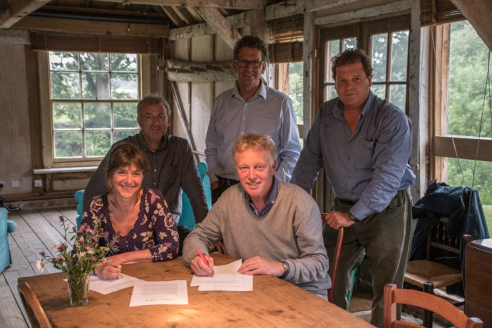 Rebecca Wrigley (Director Rewilding Britain) and Frans Schepers (Managing Director Rewilding Europe) signing the Collaborative Rewilding Agreement on 27 June at the Knepp Castle Estate. In the background (left to right): Wouter Helmer (Head of Rewilding in Rewilding Europe), Paul Jepson (Board member of Rewilding Europe) and Charlie Burrell (Chairman of the board of Rewilding Britain).