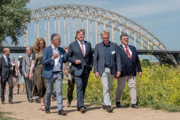King Willem-Alexander (middle) is guided by Frans Schepers (right) and Professor Hans de Kroon (left) during a short walk on the floodplains of the River Waal. 