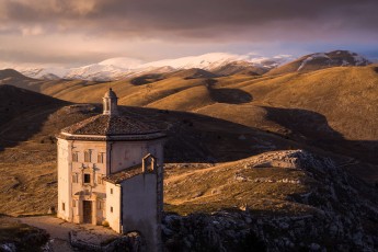 Octagonal church of S. Maria della Pietà in Calascio with mountains of Gran Sasso National Park