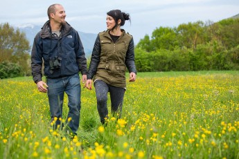 Young couple walking through a flowering field. Piani Palentini, Scurcola Marsicana, Abruzzo, Italy. May 2014