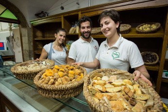 Employees showing bakery products of the "Vecchio Forno Pinocchio" in Pescasseroli. Central Apennines, Abruzzo, Italy. Aug 2014