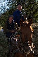 Farmer couple on a horse carriage loaded with hay in the village of Isverna, Mehedinti plateau geopark, Romania