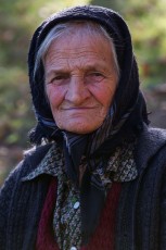 Old woman's portrait in the garden of a farmhouse in the village of Isverna, Mehedinti plateau geopark, Romania