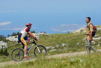 Bicyclists/mountain bikers in a long distance race with goal in Velebit Mountains rewilding area, Croatia.