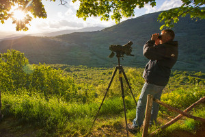 British tourist doing bear watching on a spring evening in Gioia Vecchio area in the Abruzzo National Park, Central Apennines. Abruzzo, Italy. May 2013.