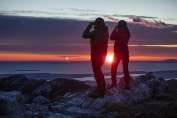 Nino Salkic and Rewilding Europe intern Stella de Zeeuw look out over the Adriatic at sunset from the Velebit Mountains.