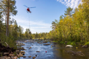Gravel drop by helicopter on Abramson river, Sweden, Nordic Taiga