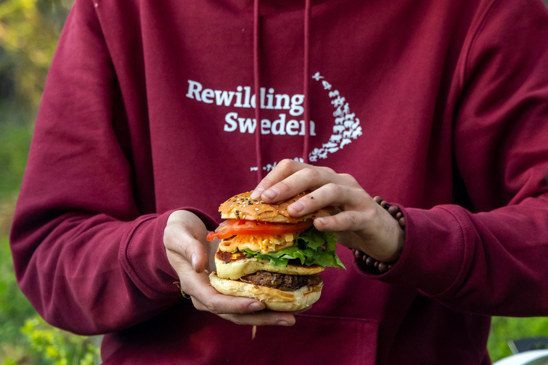 A burger cooked over fire whilst on a packrafting trip on the Hjuksån river system in the Nordic Taiga, Sweden.