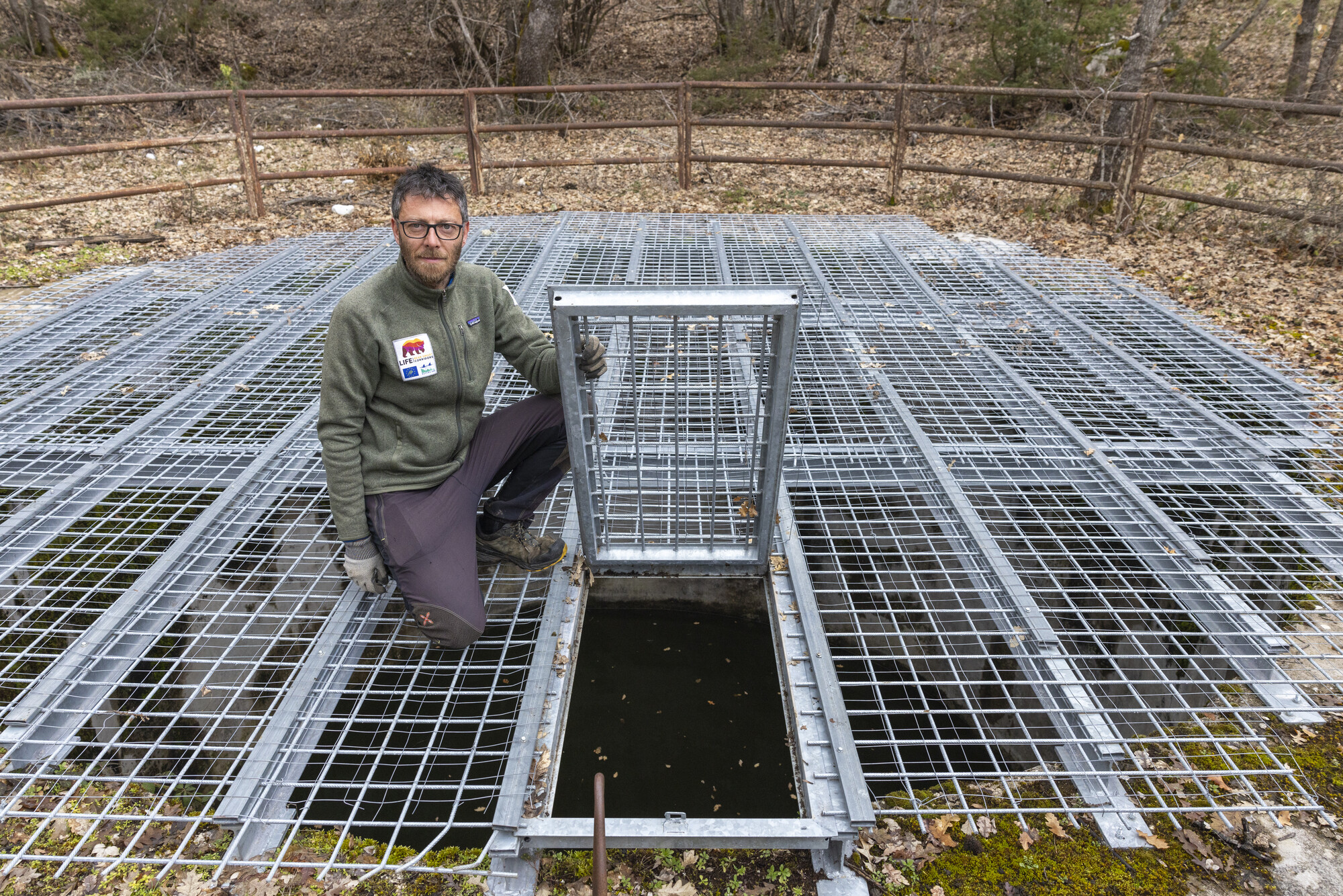 Rewilding Apennines field manager Fabrizio Cordischi with newly fitted gate on water well. Central Apennines, Italy.